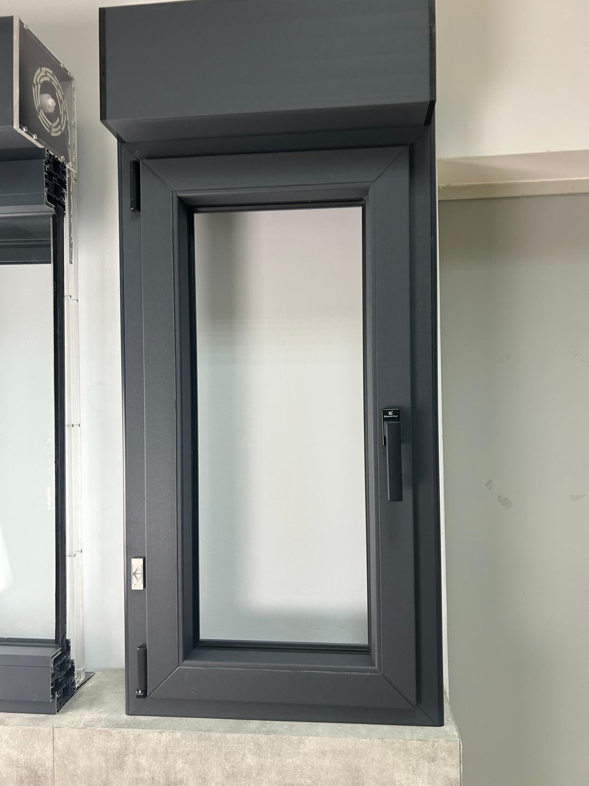 Fenêtre aluminium noire avec coffre de volet roulant intégré.